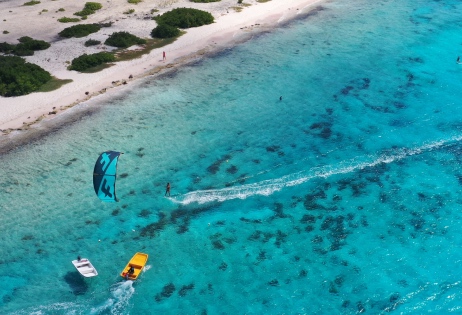 A women kitesurfing in the blue waters on bonaire.