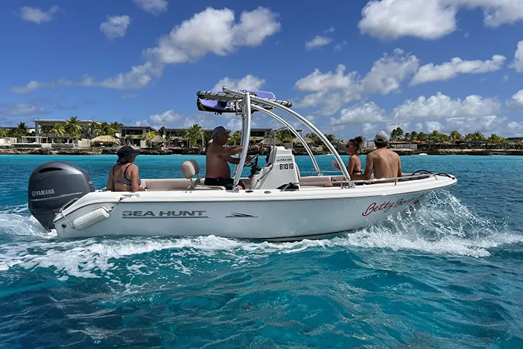 Groep mensen op een motorboot geschikt voor wakeboardavonturen op het water van Bonaire. Huur een boot of boek een wakeboardtocht bij onze partner en geniet van speciale kortingen op pick-up verhuur bij Pickup Huren Bonaire.